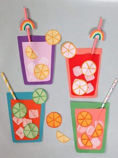 four paper cups with straws, orange slices and lemonade on them are hanging from clothes pins