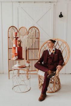 a man in a red suit sitting on a chair