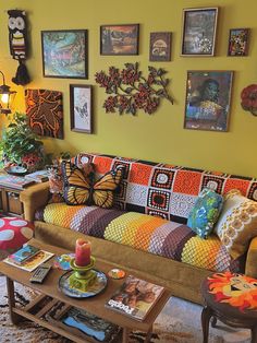 a living room filled with lots of furniture and pictures on the wall above it's coffee table