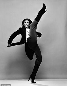 a black and white photo of a woman doing a dance move with her legs in the air