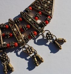 "1960's Southeast Asian vintage brass necklace with glass beading and brass dangles. 16\" total made to rest on your upper neckline or choker style. The orange beads are throughout and there are white blueish and red glass beads set in the long bars, there are 7 dandles at the bottom and all have a double bar of wrapped brass wire and attachments. All of the glass beads are in place and the thickness is 1/4\" and the main piece measures 1 3/4\" (not including the dangles) and a curved 8\" long." Asian Vintage, Choker Style, Southeast Asian, Celtic Cross, Brass Necklace, Glass Necklace, Red Glass, Glass Jewelry, Wedding Necklace