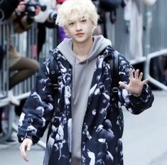 a man with blonde hair walking down the street