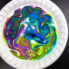 a white plate topped with colorful swirls on top of a black tablecloth covered in text