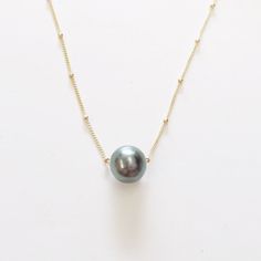 We are known for choosing only the best Grade AAA Tahitian Pearls grown in the South Pacific for our Tahitian Pearl necklaces and bracelets! This single floating 9-10 mm ROUND (not oblong and no ridges!!) Tahitian Black pearl floats and moves freely around your neck. The beautiful luster and color of each of our pearls is second to none. Online customers get the special 14k gold fill ball chain (as shown) with a 2 inch adjustable extender on the end and our signature mini puka shell at the end. Tahitian Pearls Jewelry, Preppy Jewelry, Black Pearl Necklace, Floating Necklace