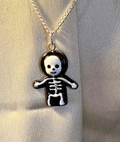 This is a really fun, kitsch piece of jewellery which is perfect for children and adults alike. The skeleton is a fun, minimal way to dress up any outfit at Halloween.  The necklace is easy and light to wear, making it a fun addition to your jewellery box.  The necklace can be made with either a silver or gold chain, making it perfect for your skin colour.  This piece of jewellery would make a lovely gift for anyone. Cute Halloween Party Jewelry, Playful Black Jewelry For Gifts, Playful Black Jewelry For Gift, Fun Black Jewelry For Halloween, Adjustable Necklaces For Halloween Costume Party, Adjustable Necklace For Halloween Gift, Fun Nickel-free Jewelry For Halloween, White Necklace For Halloween Gift, Cute Handmade Halloween Jewelry