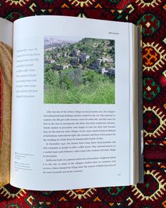 an open book sitting on top of a colorful rug