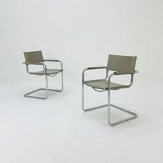 two chairs sitting next to each other on a white floor