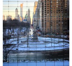 the city is covered in snow and surrounded by tall buildings