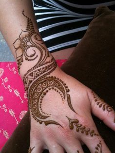 a woman's hand with henna tattoos on it