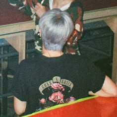 an older woman sitting on top of a red chair next to a man with grey hair