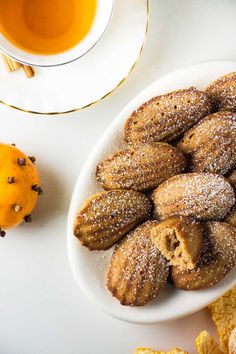 a white plate topped with pastries next to an orange and some other food items