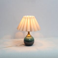 a lamp that is sitting on top of a white table cloth with a cord attached to it