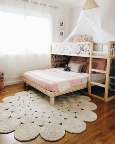 a child's bedroom with a bed and rugs on the floor