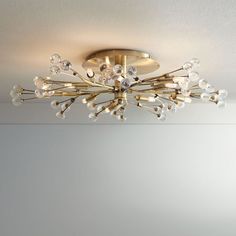 a chandelier hanging from the ceiling in a room with white walls and flooring