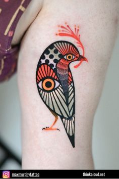 a woman's thigh with a colorful bird tattoo on her left leg and an eye in the center