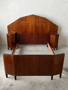 a wooden bed frame with two nightstands on each side and an attached headboard