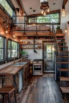 a kitchen with stairs leading up to the top floor and an open loft above it