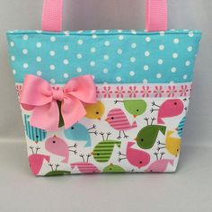 a purse with a pink bow on the front and blue polka dot background, decorated with birds