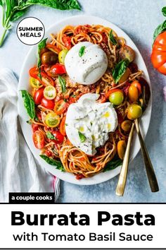 a white plate topped with pasta, tomatoes and mozzarella on top of a blue table