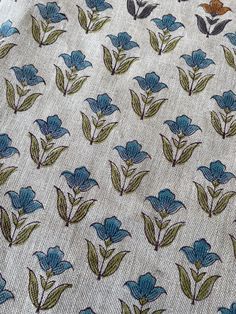 blue flowers on white fabric with green leaves