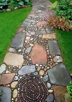 a walkway made out of rocks and stones is shown in the middle of a garden