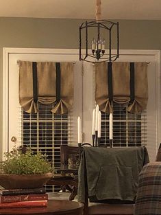 a living room filled with furniture and a chandelier hanging from the ceiling next to a window