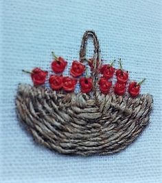 a basket with red flowers in it sitting on a table