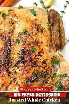 a roasted whole chicken on a plate with carrots and parsley in the background