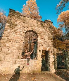 a person standing in front of an old stone building with a door and window on the side