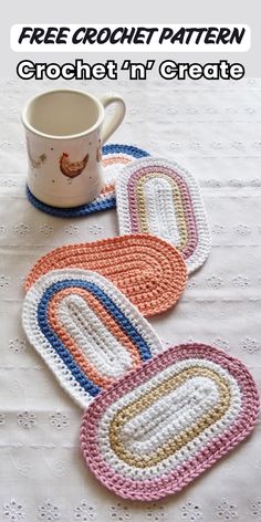 three crocheted coasters sitting on top of a table next to a coffee cup