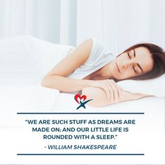 a woman laying on top of a bed next to a white wall with a quote from william shakespeare