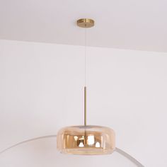 a modern light fixture hanging from the ceiling in a room with white walls and flooring