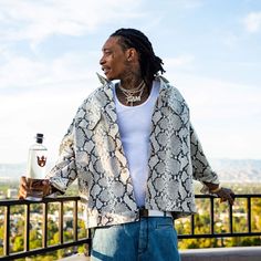 a man with dreadlocks holding a bottle of booze