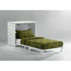 a bed with a green bedspread and white headboard on top of it