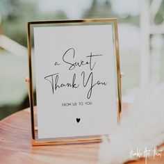 a thank card sitting on top of a wooden table