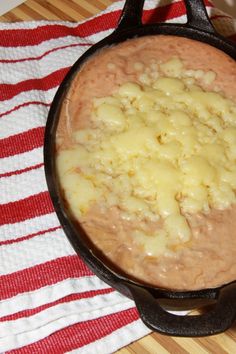 a cast iron skillet filled with food on top of a red and white towel