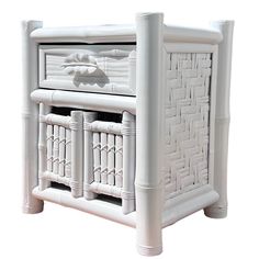 a white rattan style side table with drawers