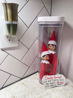 two elfs are sitting in a cup on the counter