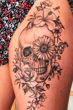 a woman's thigh with a skull and flowers on it