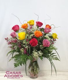 a vase filled with lots of different colored roses