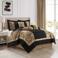 a bed with black and gold comforters in a room