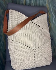 a crocheted white bag sitting on top of a blue chair