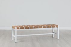 a white bench sitting on top of a hard wood floor