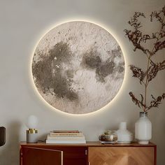 a white circular wall hanging above a wooden cabinet