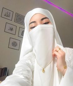 a woman wearing a white hijab covering her face