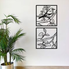 two paintings on the wall next to a potted plant