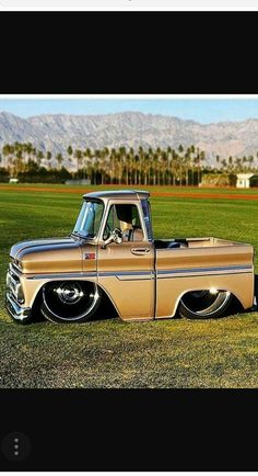 an old pick up truck parked in the grass