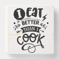 a wooden block that says eat better than i cook