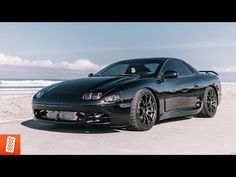 a black sports car parked on the beach