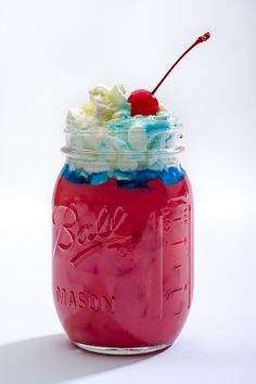 a red mason jar filled with whipped cream and a cherry on the top that says doll mash